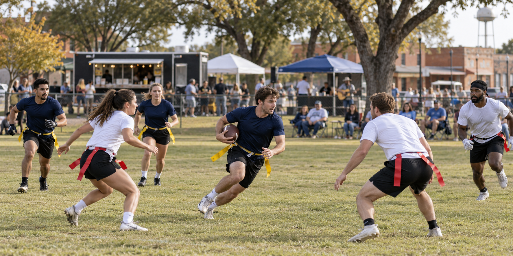 Adults playing flag football at a Texas community park, with spectators, food and live music along the sidelines.
